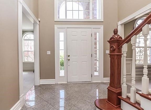 Grand front entry with gleaming tile flooring.