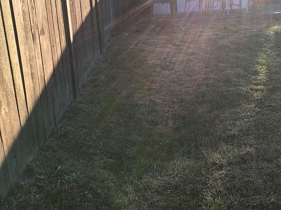 Backyard fully fenced in with shed and patio area
