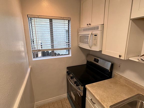 Spacious kitchen with brand new stove beadboard wall, new stainless sink and fan