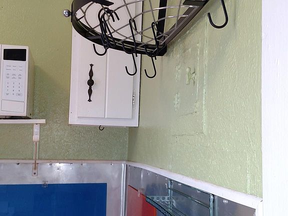 Pot rack stays, mic, stove ,frig 