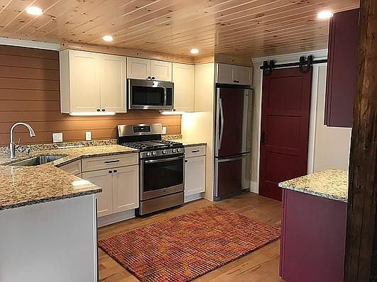 Kitchen with barn door going into the large pantry and laundry room