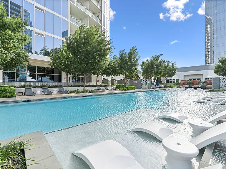 resort-style swimming pool with tanning deck + in-water lounge seating