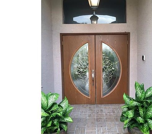 Majestic front doors that open into courtyard/pool area.