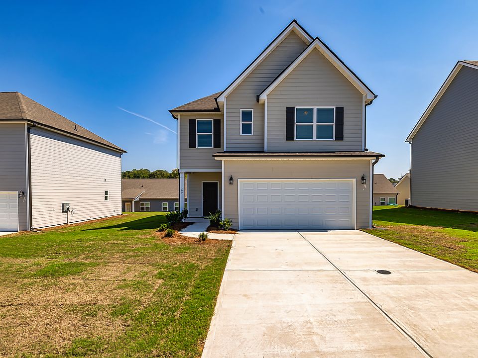 Stunning two-story home with modern siding and a two-car garage, showcasing a freshly landscaped yard and clean driveway.