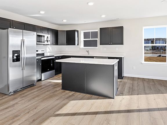 Island kitchen with gray cabinets in a DRB Homes Cranberry II plan in the Village of College Park co