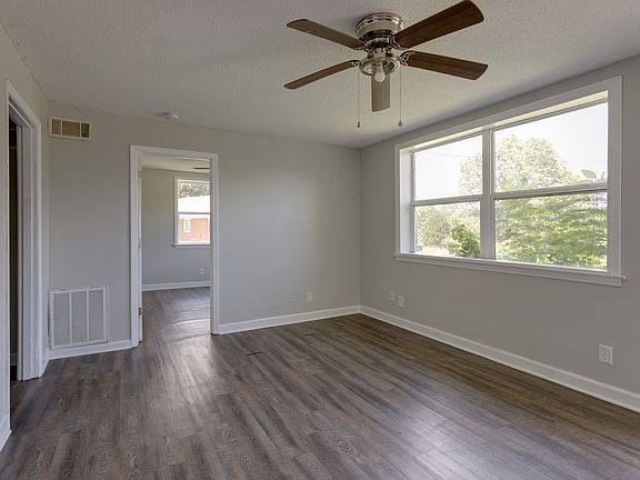 Living room with open view. Second bedroom ahead and kitchen to the left.