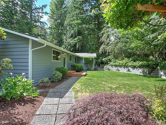 This is the view that greets you as you approach the home, surrounded by lush vegetation and beautiful landscaping. This 4 bedroom, 3 bath home is a hidden gem. Made for entertaining, the spacious kitchen and living rooms are connected by a beautiful arched opening, and both spaces spill out through double French doors onto an entertainment sized deck and patio. A tranquil waterfall feature leads you down to the expansive lawn and second spacious patio with a fire pit for evening marshmallow roasting with friends.
