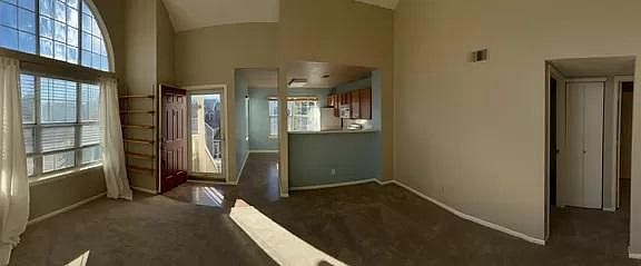Living room with tons of natural light. Hallway to bedrooms and bathrooms to the right.