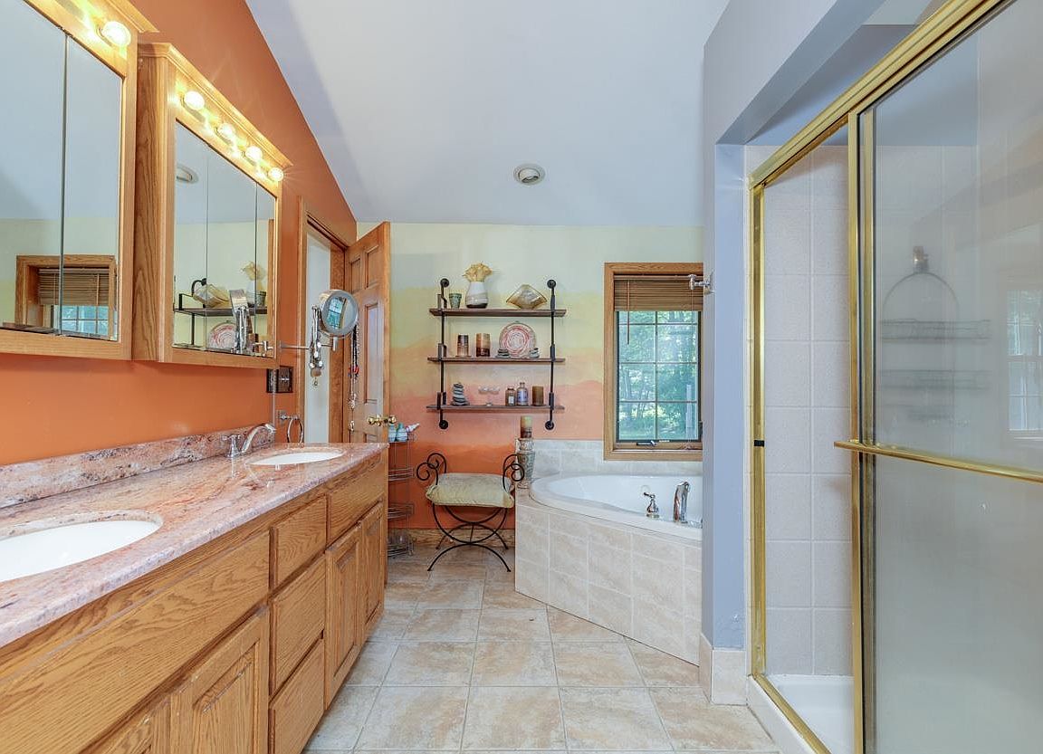Primary en-suite bathroom with a double vanity, soaking tub, and glass shower