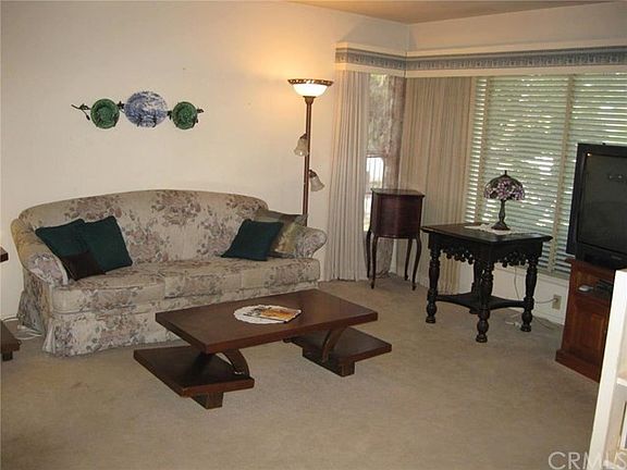 Living room with finished ceiling, carpet over original hardwood flooring- Raised foundation