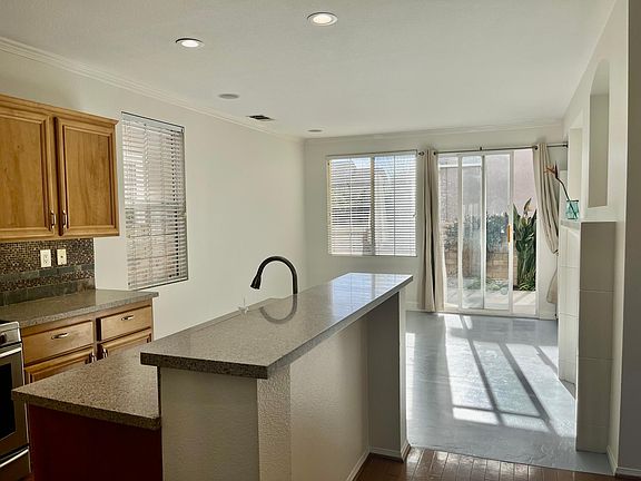 Granite countertops, wood cabinetry. Slider to back patio. Ample natural light. Recessed lighting.