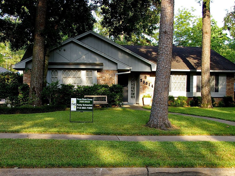 House is centered around trees on this wooded lot