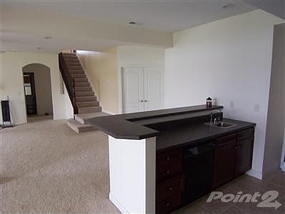 Huge finished lower level has family room with wet bar, neutral carpet, neutral paint, bedroom and f