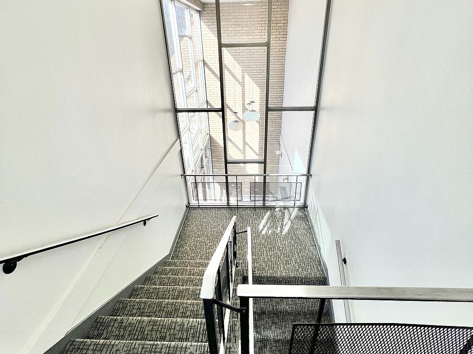 Experience the airy ambiance of this modern staircase, bathed in natural light.
