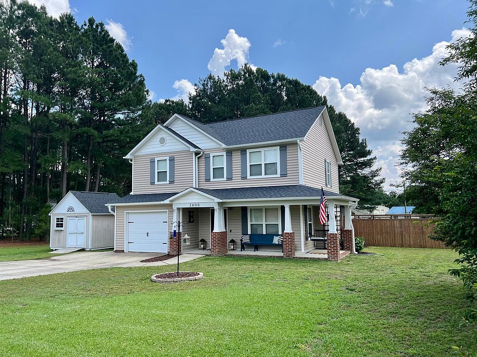 Large front porch, 1 car garage, and storage shed with ramp