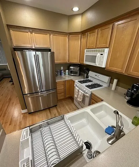 Kitchen with tall breakfast counter, dishwasher, microwave, refrigerator, and gas stove and oven