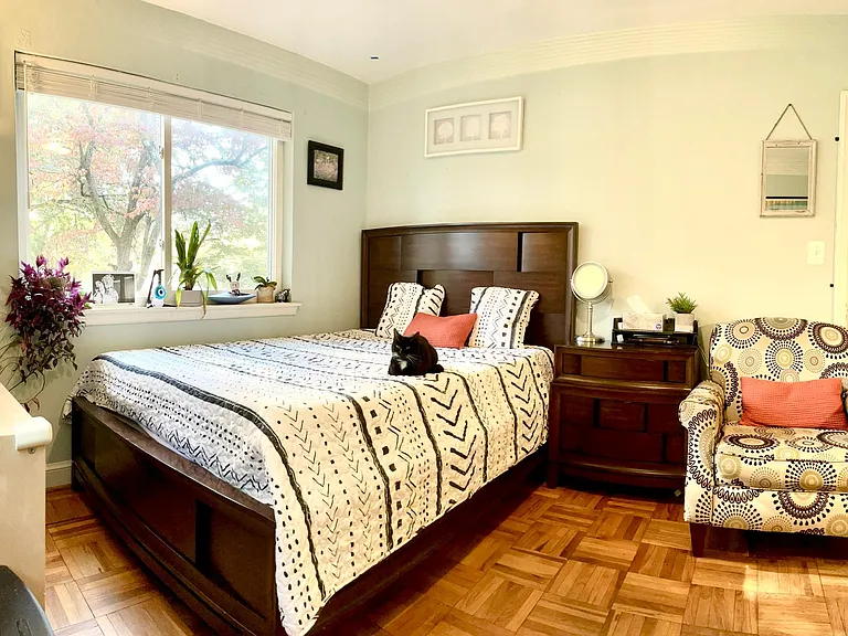 Guest Bedroom # 1 with a Queen-sized bed, a chest, an arm chair, and some low bookshelves.