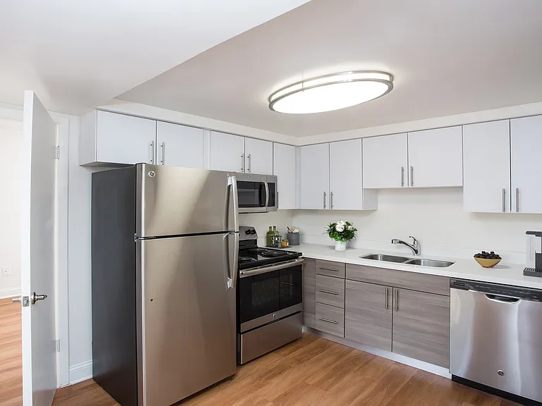 Renovated kitchen with quartz countertops and stainless steel appliances