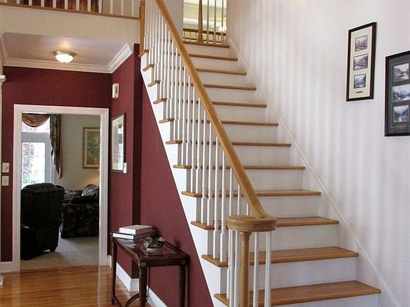 Two story foyer with oak tread stairs, veloute railing, overlook on second floor.