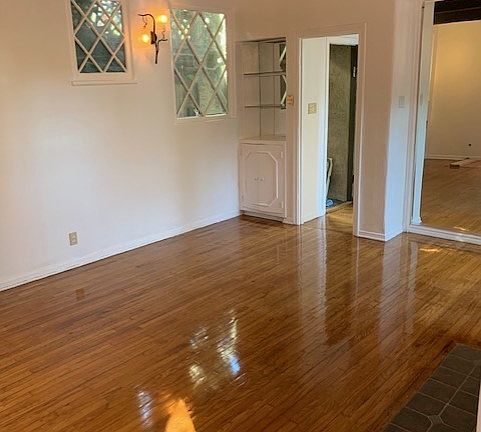 Front entry door to living room, with diamond, patterned windows, and beautiful iron walls sconces.