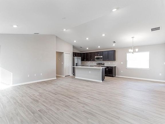 Enjoy an open living area with airy volume ceilings and luxe, low-maintenance vinyl plank flooring -