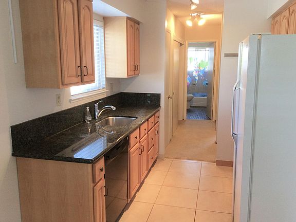 Kitchen with maple cabinets, granite counter tops, stainless steel sink. Wood blinds.