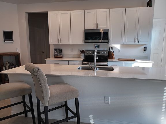 Eat in kitchen island with power outlets, sink, and Samsung dishwasher.