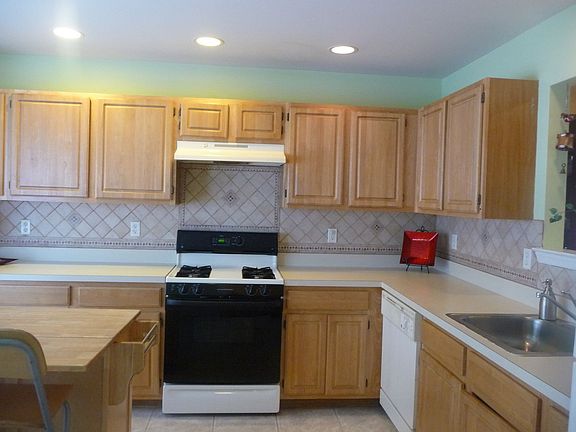 kitchen w/ new floors and new ceramic tile backsplash.recessed lights and bay 