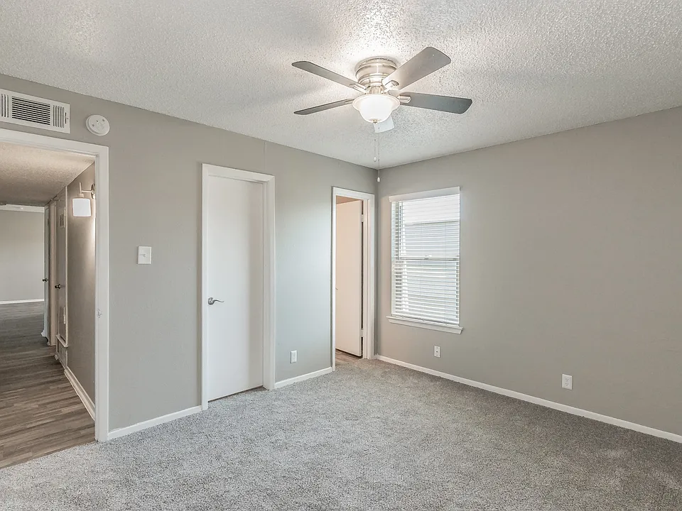 Comfortable bedroom with ceiling fan and soft carpeting