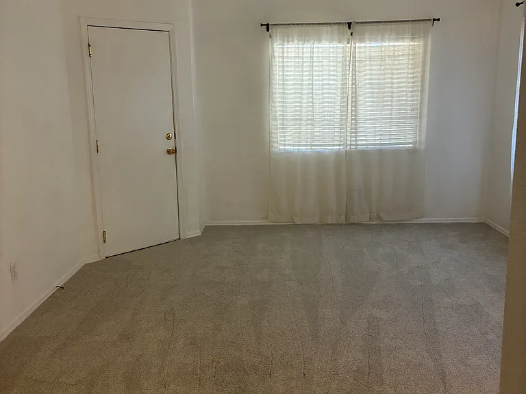 Living room with new carpet with door leading to the two car garage.
