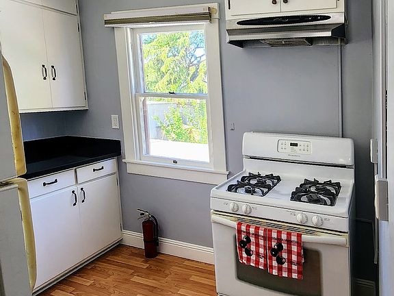 The kitchen is also on the second story and features views of the trees as well as sleek black countertops.