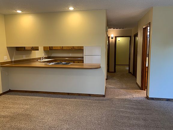 View into kitchen, on right side is bathroom, then laundry, and looking into the 2 bedrooms at the end of the hall
