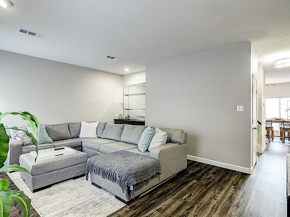 An alternate view of this modern space shows an open floor plan flowing into the dining room towards the exterior of the home.