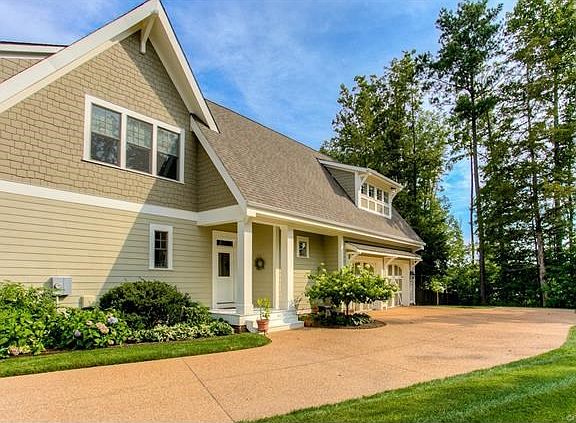 Side view of home, pedestrian entrance to kitchen, side load garage and driveway extension