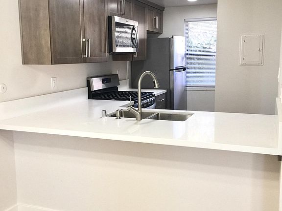 High end fitted kitchen cabinets with plenty of space to dine at the modern quartz counter.