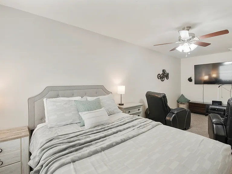 Bedroom 3 features a queen size bed, a fan, 2 nightstands, tv and 2 lounge chairs