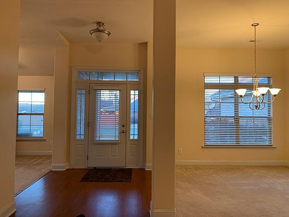 Front entrance with hardwood flooring between bonus room and dining room