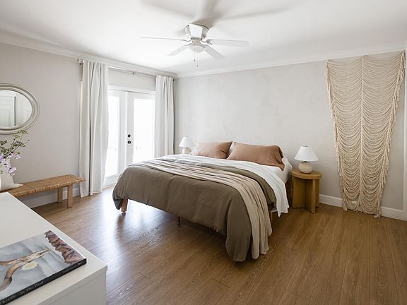 Spacious primary bedroom with king bed and French doors to outdoor shower and private patio.
