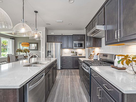 Double ovens with cooktop and range hood, as well as a microwave complete the new construction kitch