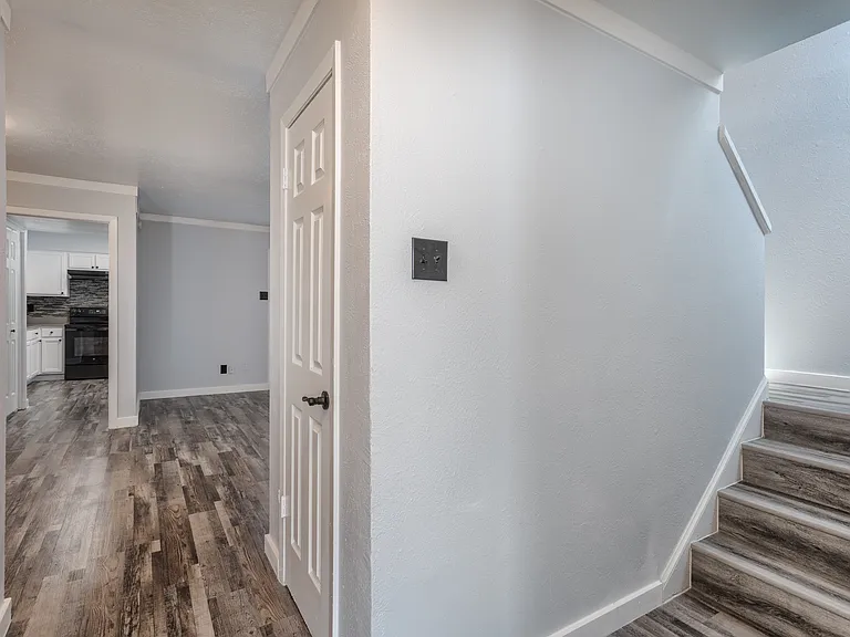 Entryway to upstairs area and open living and dining area