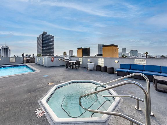 Rooftop at sunset with spa, bbq area, and swimming pool.