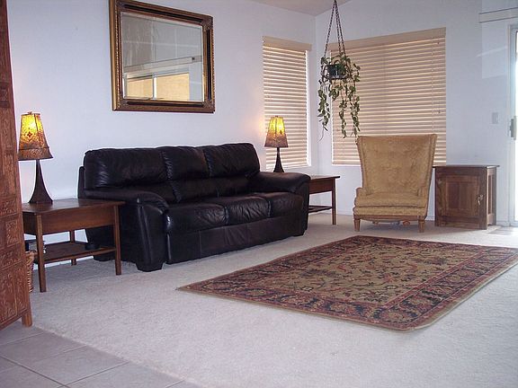Living room prewired for surround sound with beautiful real wood blinds.