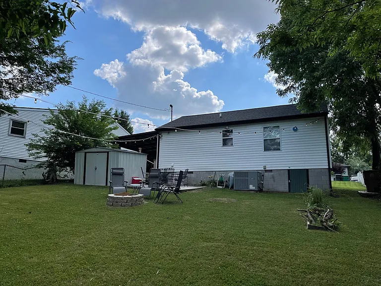 Back yard with shed, market lights, and fire pit