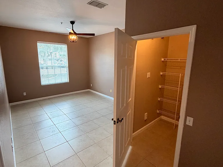 Master bedroom with large walk-in closets, complete with built-ins. There is also a master en-suite bath. Master bedroom has a luxury updated fan with remote to turn off the lights from bed.