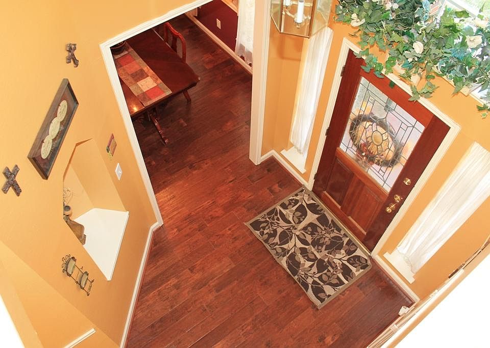 A view of the light & bright 2-story Entry w/leaded glass front door, wood flooring and art niche.