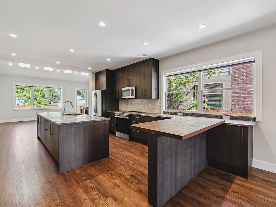 Fully equipped kitchen including electric range with cooktop, microwave oven, full size refrigerator / freezer, dishwasher, and granite countertops.