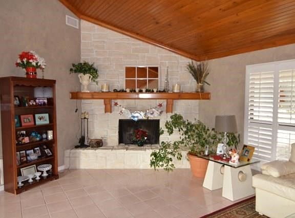 AUSTIN STONE, TILE FLOORS & WOOD FIREPLACE ENHANCES THE AMBIANCE OF THIS GREAT ROOM.