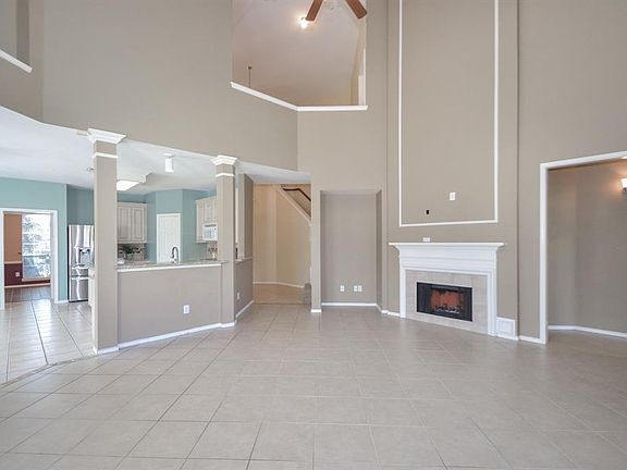 The family room features two story ceilings, tile flooring and this beautiful gas fireplace.