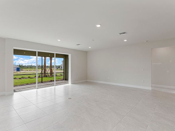 Gathering room with sliding glass doors to the lanai, proving plenty of natural light