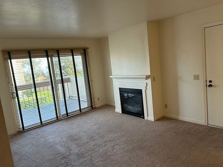 Living room with gas fireplace. Large balcony with sliding glass door.